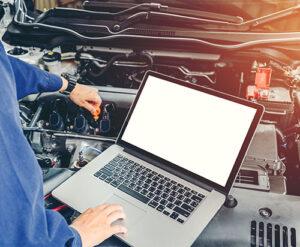 auto repair service using laptop on car